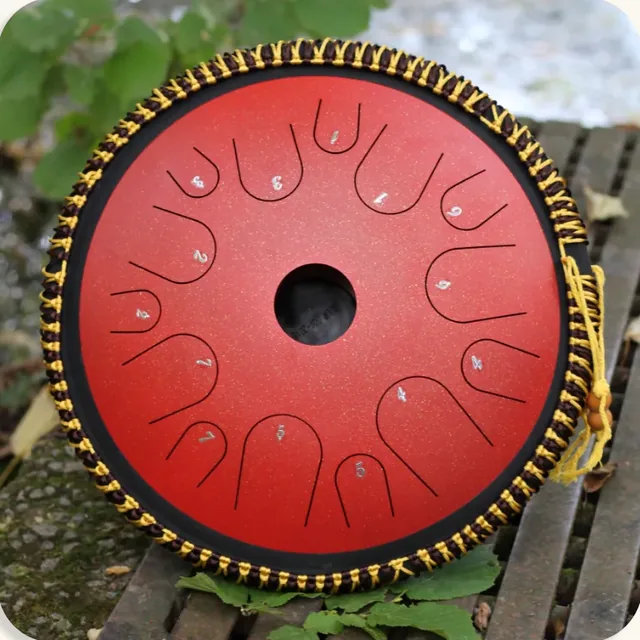 Tongue drum Exodrum Virtuoso rouge posé sur un banc